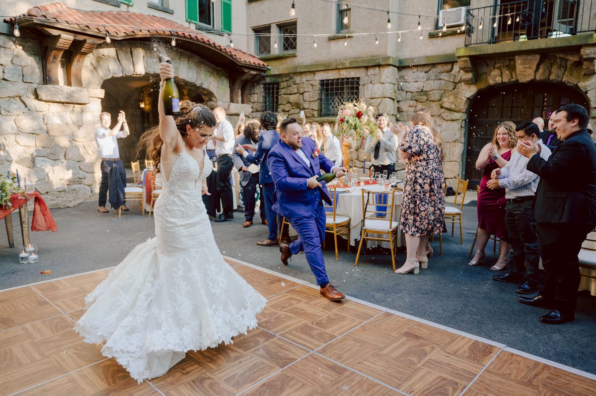 How do I explain the sincere and true feelings that Izzy and Brendan shared on their wedding day at one of the most magical place Arrow Park in Monroe NY. Izzy is Opera singer and Brendan is a Chef who owns his own restaurant called Circle in Newton, NJ got married at Arrow Park NY a month ago and it got real festive and wild real fast. But let's come back to the wild party in a bit and talk about their morning first. Izzy and Brendan both got ready onsite at Arrow Park, great thing about Arrow Park is that it has enough rooms to host all their bridal party and family. With all of Izzy and Brendan's loved ones onsite Izzy and Brendan's wedding prep was fun. No drama and no one running late, Izzy and Brendan's wedding prep went so smooth with everyone's cooperation! Izzy got into her dress with her mom and sister by her side, then we went down to the back steps for Izzy and Brendan's first look. Oh boy Brendan got super emotional for their first look, he couldn't even turn around to look at Izzy with all the happy emotions rushing to him. Izzy held his hand and they looked at each other. The two of them cried. Sharing such a beautiful first look Izzy and Brendan walked out to the front of Arrow Park for group and family photos. It was an August wedding so I kept everyone in the shade not too far, making it simple easy for group and family photos are important job to wedding photographer. After all the formal group photos were done, it was almost time for their wedding ceremony at the garden. Beautiful decor and floral arrangements were set up in the garden ready for Izzy and Brendan's wedding ceremony, guest started to walked down the long driveway and down the steps and found seats waited for the bride and groom to walk down the aisle. Brendan now standing in the front next to the priest, started tearing up as soon as he saw Izzy coming down the aisle escorted by her father. The two linked their eyes at each other and in the most loving way possible looked at each other through out the ceremony then sealed it with the first kiss as husband and wife. As calm and peaceful as Izzy and Brendan's wedding ceremony was, the two entered their reception each with (shaken) champagne bottles in their hands, everyone and anyone in Izzy and Brendan's way got sprayed with Champagne! They jumped, pouring Champagne into their friends mouth straight out of the bottle, then each drank some out of the bottle. Building the excitement in to their epic wedding party, Izzy and Brendan held each others hands and walked into the center of Arrow Park's courtyard and danced their first dance. Smoke and smell of freshly cooked dinner being prepared by Brendan's friends at Promises Kept Hudson Valley NY was filling the air, as first courses were being served. Happiest sound of plates, utensils and people chatting, Izzy and Brendan sat at their sweetheart table to enjoy their wedding dinner prepared by Promises Kept Hudson Valley NY. Then the evening got deeper and darker and vibe got stronger and crazier. Music got louder and everyone was in their element celebrating Izzy and Brendan on their wedding day. Izzy and Brendan's Arrow Park Monroe NY Wedding documented by by Karis | Hey Karis | Catskills, Hudson Valley NY elopement and wedding photographer | Brooklyn NY elopement and wedding photographer | Manhattan NY elopement and wedding photographer | Hey Karis is fun documentary wedding and elopement photographer.