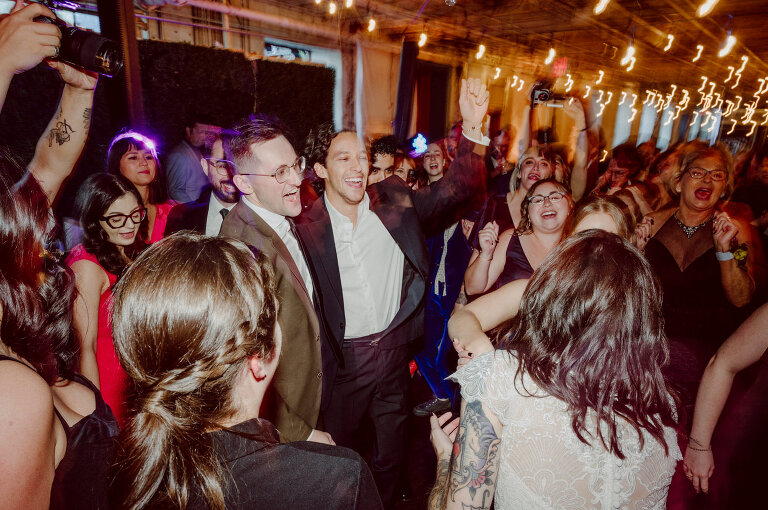 Nestled in the heart of Paterson, New Jersey, The Art Factory stands out as a unique and captivating wedding venue. This expansive warehouse-turned-loft space, with its exposed brick walls and soaring ceilings, serves as a canvas for couples seeking a distinctive backdrop for their special day. On the memorable evening of October 8, 2023, I had the privilege of capturing the union of Blair and Eric within the enchanting confines of The Art Factory. The choice of this venue perfectly mirrored the essence of Blair and Eric's artistic souls. As creators themselves, the raw, industrial aesthetic and creative atmosphere of The Art Factory resonated deeply with their vision for the celebration. Blair and Eric, surrounded by a diverse congregation of fellow art enthusiasts, exchanged vows in a ceremony that seamlessly blended tradition with contemporary flair. The venue's unique charm set the stage for a wedding that was as visually stunning as it was heartfelt. The exposed brick walls and high ceilings provided a rustic yet elegant backdrop, enhancing the vibrancy of every moment captured through my lens. The ambiance was alive with the energy of creativity, a fitting tribute to the artistic journey that Blair and Eric embarked upon together. As the evening unfolded, it became evident that The Art Factory was not merely a venue; it was an extension of Blair and Eric's artistic expression. The celebration was a testament to their love, surrounded by an eclectic mix of family and friends who shared in their passion for creativity. Blair and Eric's wedding at The Art Factory in Paterson, NJ, was a masterpiece of love, where every detail reflected the unique canvas of their relationship. It was an honor to document the union of two artists in a space that echoed the beauty of their shared journey. In the end, The Art Factory not only bore witness to a wedding but also played a vital role in shaping an unforgettable chapter in Blair and Eric's artistic love story. The October evening marked not just a celebration of marriage but a fusion of art, love, and the beauty of creative souls coming together. Blair and Eric's Artsy Warehouse Loft NJ Wedding photographed and documented by by Karis | Hey Karis | Catskills, Hudson Valley NY elopement and wedding photographer | Brooklyn NY elopement and wedding photographer | Manhattan NY elopement and wedding photographer | Hey Karis is fun documentary wedding and elopement photographer.