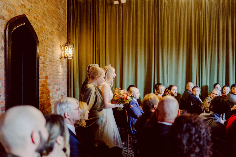 Just days before Halloween, on October 28th, Katie and Craig celebrated their enchanting wedding at the iconic Bowery Hotel in NYC. Having previously photographed an intimate wedding at The Bowery Hotel during the challenges of COVID in 2020, returning to capture the magic of Katie and Craig's celebration was a joyous experience.

The Bowery Hotel, a symbol of the "OLD New York," boasts a rich history intertwined with the stories of its residents. The Bowery Terrace, adorned in classic old-world style, features wood-beamed 13-foot ceilings, salvaged brick walls, Moroccan tiled floors, antique tapestries, an expansive outdoor terrace, and a captivating glazed fireplace. Described by the Huffington Post as a hidden gem with a relaxed and warming atmosphere, The Bowery Terrace served as the perfect backdrop for this magical occasion.

Katie and Craig began their day at The Bowery Hotel in a bridal suite with a terrace spacious enough to host a small wedding. It was on this vast terrace that they shared their first look, exchanging glances, conversations, and hugs. Their private moment culminated in the tender reading of their vows and letters to each other, setting the tone for a day filled with intimacy and love.

Following the intimate vow exchange, we ventured to Bond Street, where a magical bright yellow Ginkgo Tree awaited. The grounds beneath were adorned in a sea of yellow, a sight that perfectly aligned with Katie and Craig's shared love for nature and stars. The decision was unanimous, and we headed for the captivating Yellow Ginkgo Tree in the heart of Manhattan. With Bond Street serving as our backdrop, we captured stunning photos that reflected the essence of this unique couple.

Returning to The Bowery Hotel, families awaited their formal portraits with Katie and Craig. The Bowery Terrace came alive with wedding guests, artists, musicians, and beautiful New Yorkers, all eagerly anticipating the ceremony. As Katie walked down the aisle escorted by her parents, Craig's eyes welled with tears, encapsulating the emotional beauty of the moment.

The wedding ceremony, sweet and humorous, was officiated by their friend Michael Williams. Following the heartfelt exchange of vows, guests spilled out onto the outdoor terrace for a delightful cocktail hour. Meanwhile, the staff at The Bowery Hotel, alongside Planner Ani Wolff and her team, worked their magic, transforming the room into a spooky yet super chic version of "Harry Potter's Hogwarts Great Hall."

The remainder of Katie and Craig's wedding unfolded just as expected—fabulous and magical. The Bowery Hotel provided the perfect canvas for their love story, creating a celebration that will be cherished for years to come.
Katie and Craig's The Bowery Hotel, The Bowery Terrace wedding documented by by Karis | Hey Karis | Destination Wedding Photographer | Manhattan, Catskills, Hudson Valley, Brooklyn and NJ | Destination Elopement, Destination Wedding Photographer | Hey Karis is fun documentary wedding and elopement photographer based in NY, NJ.