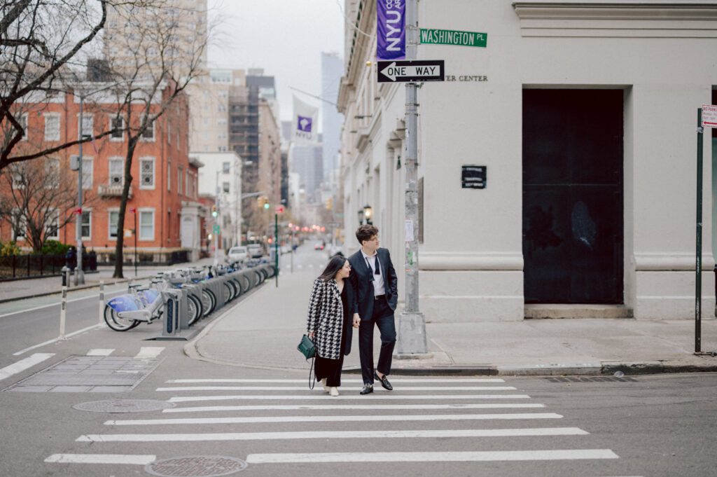 The city streets were refreshingly empty and surreal on an early Saturday morning in chilly December. With all the college students away for winter break, Washington Square Park, surrounded by NYU buildings and dorms, was particularly deserted. Erika and Andrei arrived around 7:30 am, stepping out of their Uber to meet me at the iconic Washington Square Arch. Erika looked stunning in a black velvet romper, while Andrei sported a tuxedo with a "purposely" undone bowtie, creating that effortlessly cool rockstar look for the morning. Together, we ventured through the chilly, deserted streets of Greenwich Village, making our way to Bond Street and concluding the engagement session in the vibrant East Village by the cube. Along the way, we spontaneously paused at corners, benches, and in front of unique buildings, capturing the essence of their love against the backdrop of the city. Erika and Andrei's engagement session in Greenwich Village was truly delightful, and I find myself eagerly anticipating their wedding next year at The Box House Hotel in Brooklyn—a venue that has long been on my bucket list. The blend of the picturesque Greenwich Village streets and the upcoming wedding at such a coveted location promises a celebration filled with love and unforgettable moments. Erika and Andrei's Washington Square Park NYC, Washington Mews NYC, Greenwich Village NYC documented by by Karis | Hey Karis | Destination Wedding Photographer | Manhattan, Catskills, Hudson Valley, Brooklyn and NJ | Destination Elopement, Destination Wedding Photographer | Hey Karis is fun documentary wedding and elopement photographer based in NY, NJ.
