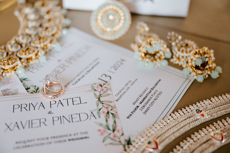 I first crossed paths with Xavier a few years back at Danny and Andy's wedding, where he stood as one of the groomsmen at The Ryland Inn in 2021. When Xavier and Priya's own wedding day approached, I was deeply honored that he remembered me and reached out to discuss capturing their special day. Meeting Priya and Xavier together during their engagement session in Princeton, NJ was an essential part of my process. It allowed me to delve into their personalities and witness the beautiful chemistry they shared. Engagements sessions, for me, serve as a cornerstone in establishing a genuine connection with my couples before the main event. Priya and Xavier both started the wedding day at the Hyatt Regency in Jersey City, a venue boasting panoramic views of the Hudson River and the iconic Manhattan skyline. Against this breathtaking backdrop, they readied themselves, shared a heartwarming first look along the Hudson River Waterfront Walkway, then shortly after Priya and Xavier's family and friends joined them for photos. As Priya watched from a balcony, Xavier's Baraat procession unfolded below, a lively affair marked by music, drums, and joyous celebrations. Following the Baraat wedding guests ascended to the wedding ceremony room at the Hyatt Regency, where a beautifully adorned Mandap awaited their union. The cocktail hour tantalized guests with an array of delicious Indian cuisine, setting the stage for the grand entrance into the candlelit reception hall. Priya and Xavier stepped in, resplendent in their evening attire, launching into their first dance. This was followed by the traditional Filipino money dance, Throughout the evening, dance performances, heartfelt parent dances, and touching speeches filled the air with love and laughter. Priya and Xavier's faces radiated with pure joy, reflecting the love that enveloped them on their special day. Priya and Xavier Hyatt Regency Jersey City NJ wedding documented by by Karis | Hey Karis | Destination Wedding Photographer | Manhattan, Catskills, Hudson Valley, Brooklyn and NJ | Destination Elopement, Destination Wedding Photographer | Hey Karis is fun documentary wedding and elopement photographer based in NY, NJ.