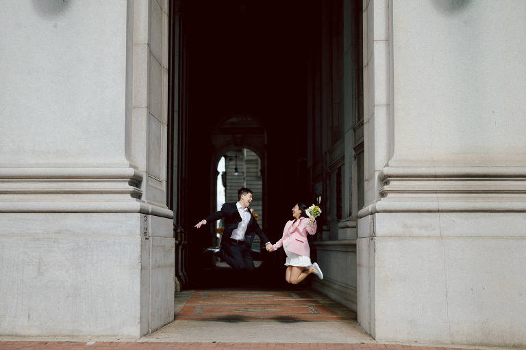 Alicia and Kevin made the bold decision to elope in the heart of the Big Apple before bidding adieu to city life and embracing suburban tranquility in New Jersey. Their choice resonates; after all, there's something undeniably magnetic about tying the knot in NYC that sets it apart from anywhere else in the world.
Less than two weeks before their planned elopement at NYC City Hall, Alicia and Kevin reached out to me. I promptly scheduled a call to delve into the details, eager to understand their vision and expectations for their special day. It was essential for me to grasp their vibe and personalities; forging this connection and building relationship before the big day is super important to me.
On April 5, I rendezvoused with Alicia and Kevin outside The Office of the City Clerk - Marriage Bureau. Despite hoping for a warm, sunny day, the brisk April air lingered, accompanied by a chilly breeze. Accompanied by a friend who served as their witness, we walked into the building.
My camera was ready from outside documenting Alicia and Kevin, as I wanted to tell their story from beginning to end. 
Inside, we navigated the bureaucratic procedures, clicking away at Alicia and Kevin as they pleasantly waited for their number to be called. With paperwork signed and formalities concluded, Alicia and Kevin became husband and wife in the blink of an eye.
We stayed a while longer inside the marriage bureau took the opportunity to capture some timeless moments posing on the iconic green sofa and NYC City Hall wall mural. Then we journeyed outside and wandered the vibrant bustling streets of NYC for some more photos. And what better way to conclude Alicia and Kevin's NYC City Hall elopement than with a quintessential New York slice.
Alicia and Kevin NYC City Hall NY Elopement documented by by Karis | Hey Karis | Destination Wedding Photographer | Manhattan, Catskills, Hudson Valley, Brooklyn and NJ | Destination Elopement, Destination Wedding Photographer | Hey Karis is fun documentary wedding and elopement photographer based in NY, NJ.