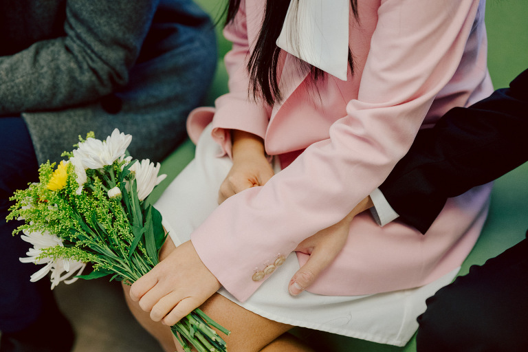 Alicia and Kevin made the bold decision to elope in the heart of the Big Apple before bidding adieu to city life and embracing suburban tranquility in New Jersey. Their choice resonates; after all, there's something undeniably magnetic about tying the knot in NYC that sets it apart from anywhere else in the world.
Less than two weeks before their planned elopement at NYC City Hall, Alicia and Kevin reached out to me. I promptly scheduled a call to delve into the details, eager to understand their vision and expectations for their special day. It was essential for me to grasp their vibe and personalities; forging this connection and building relationship before the big day is super important to me.
On April 5, I rendezvoused with Alicia and Kevin outside The Office of the City Clerk - Marriage Bureau. Despite hoping for a warm, sunny day, the brisk April air lingered, accompanied by a chilly breeze. Accompanied by a friend who served as their witness, we walked into the building.
My camera was ready from outside documenting Alicia and Kevin, as I wanted to tell their story from beginning to end. 
Inside, we navigated the bureaucratic procedures, clicking away at Alicia and Kevin as they pleasantly waited for their number to be called. With paperwork signed and formalities concluded, Alicia and Kevin became husband and wife in the blink of an eye.
We stayed a while longer inside the marriage bureau took the opportunity to capture some timeless moments posing on the iconic green sofa and NYC City Hall wall mural. Then we journeyed outside and wandered the vibrant bustling streets of NYC for some more photos. And what better way to conclude Alicia and Kevin's NYC City Hall elopement than with a quintessential New York slice.
Alicia and Kevin NYC City Hall NY Elopement documented by by Karis | Hey Karis | Destination Wedding Photographer | Manhattan, Catskills, Hudson Valley, Brooklyn and NJ | Destination Elopement, Destination Wedding Photographer | Hey Karis is fun documentary wedding and elopement photographer based in NY, NJ.