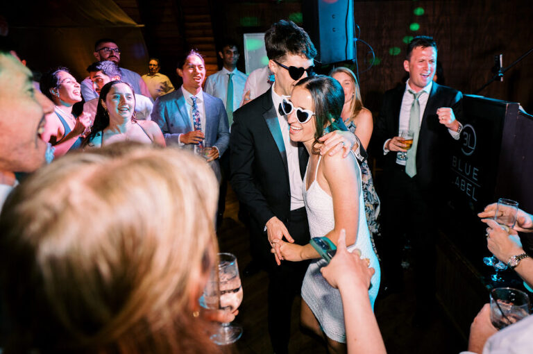 Malia and Aidan, currently residing in DC with their beloved pup Max, envisioned a wedding that reflected their laid-back, natural style. When we first chatted back in February 2023, they emphasized their desire for relaxed, fun, and candid photos that captured genuine moments. Choosing The Barn at Perona Farms was a perfect fit for Malia and Aidan. Nestled amidst charming rustic surroundings and abundant nature, the venue complemented their preference for an authentic and unposed wedding day experience. The ceremony took place outdoors on the lush lawn of The Barn at Perona Farms, exactly as they had envisioned – sweet, whimsy, and just the way they wanted it. Guests enjoyed a leisurely cocktail hour accompanied by live music courtesy of the talented Blue Label Band. The air was filled with the sounds of laughter and the clinking of wine glasses as everyone soaked in the joyful atmosphere. As the evening progressed upstairs at The Barn, the ambiance was transformed by Moonlit Acres' stunning floral arrangements, candles, and elegant drapes. The space slowly filled with guests, reconnecting and sharing stories, delighted to be together again. Then, the moment everyone had been waiting for: Malia and Aidan entered the room, surrounded by loved ones, and shared their first dance together. Malia and Aidan's The Barn at Perona Farms NJ wedding documented by by Karis | Hey Karis | Destination Wedding Photographer | Manhattan, Catskills, Hudson Valley, Brooklyn and NJ | Destination Elopement, Destination Wedding Photographer | Hey Karis is fun documentary wedding and elopement photographer based in NY, NJ.