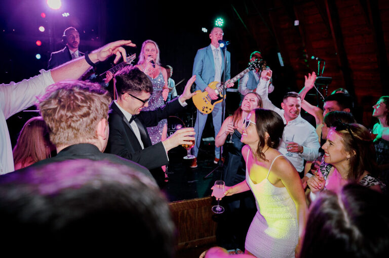 Malia and Aidan, currently residing in DC with their beloved pup Max, envisioned a wedding that reflected their laid-back, natural style. When we first chatted back in February 2023, they emphasized their desire for relaxed, fun, and candid photos that captured genuine moments. Choosing The Barn at Perona Farms was a perfect fit for Malia and Aidan. Nestled amidst charming rustic surroundings and abundant nature, the venue complemented their preference for an authentic and unposed wedding day experience. The ceremony took place outdoors on the lush lawn of The Barn at Perona Farms, exactly as they had envisioned – sweet, whimsy, and just the way they wanted it. Guests enjoyed a leisurely cocktail hour accompanied by live music courtesy of the talented Blue Label Band. The air was filled with the sounds of laughter and the clinking of wine glasses as everyone soaked in the joyful atmosphere. As the evening progressed upstairs at The Barn, the ambiance was transformed by Moonlit Acres' stunning floral arrangements, candles, and elegant drapes. The space slowly filled with guests, reconnecting and sharing stories, delighted to be together again. Then, the moment everyone had been waiting for: Malia and Aidan entered the room, surrounded by loved ones, and shared their first dance together. Malia and Aidan's The Barn at Perona Farms NJ wedding documented by by Karis | Hey Karis | Destination Wedding Photographer | Manhattan, Catskills, Hudson Valley, Brooklyn and NJ | Destination Elopement, Destination Wedding Photographer | Hey Karis is fun documentary wedding and elopement photographer based in NY, NJ.