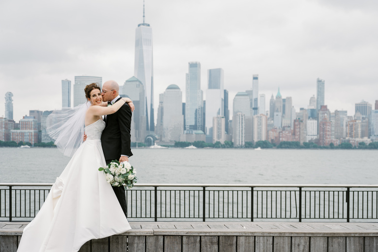 I first connected with Rachel through a DM on Instagram. From that initial message, our conversations quickly evolved, and soon I was part of her wedding journey. Rachel's bright, bubbly personality shone through as she excitedly shared stories about her and Zach, including his proposal. When I met them for their engagement session in the Meatpacking District of New York City, it was clear they were made for each other. The way Zach’s eyes lit up when he looked at Rachel, and how their contrasting personalities complemented one another, was undeniable. It felt like hearts were falling from the sky that day. Their wedding at Liberty House in Jersey City on June 30, 2024, was just as magical. All the love and emotions were on full display, and the excitement was palpable in the air. Both Rachel and Zach’s families were overjoyed to witness their children marry the loves of their lives. You could see it on their faces – pure happiness. In keeping with Jewish tradition, Rachel and Zach held a beautiful Badeken and Ketubah signing, surrounded by their closest family and friends. Despite the rain, the ceremony was moved indoors at Liberty House, and thanks to the venue’s impressive panoramic windows, it still felt as if we were outside, with the stunning city skyline as our backdrop. Rachel and Zach made their grand entrance into the reception with incredible energy, setting the tone for an evening filled with love, laughter, and celebration. The rest of the night was pure joy as their family and friends danced the night away, making unforgettable memories at Liberty House. Rachel and Zach Liberty House Jersey City NJ wedding documented by by Karis | Hey Karis | Destination Wedding Photographer | Manhattan, Catskills, Hudson Valley, Brooklyn and NJ | Destination Elopement, Destination Wedding Photographer | Hey Karis is fun documentary wedding and elopement photographer based in NY, NJ.