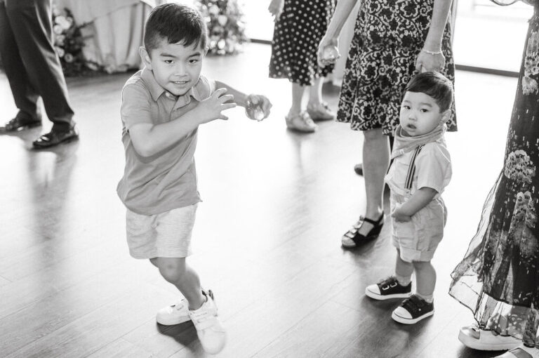 Leah and Kevin’s wedding was nothing short of enchanting—fitting for two fellow Harry Potter fans! From the emotional first look to their joyous celebration surrounded by family and friends, their special day was filled with love, laughter, and memorable moments.
Their day began early at The View at Lincoln Park, one of Jersey City’s newest and most unique wedding venues, part of the esteemed Landmark Venues collection. Nestled within the historic Lincoln Park, The View offers a modern yet timeless space with breathtaking scenery. The venue’s design is a stunning adaptive reuse of the original Lincoln Lodge (est. 1929), featuring preserved stone facades, timber beams, and antique fixtures. This blend of contemporary elegance and historic charm makes it a truly one-of-a-kind setting for weddings.
When I arrived, I was excited to explore the property and its surroundings. The View’s lush grounds, picturesque willow tree, and nearby landmarks, including the Lincoln Park Fountain, provide endless opportunities for stunning photographs. The morning was quiet as Leah and her bridesmaids arrived, carrying their dresses over their shoulders, and settled into the spacious bridal suite. Later, Kevin and their families arrived, and the anticipation began to build.
Leah and Kevin’s first look by the willow tree was a moment to remember. As the wind danced through the branches, tears filled Leah’s eyes as they read their vows to each other—an intimate, heartfelt exchange that perfectly set the tone for the day.
Guests began filling the chairs in Lincoln Room (the third-floor ceremony space), a modern area with large windows that allow natural light to flood in. This versatile room offers an elegant setting for ceremonies, with views of the surrounding park and cityscape. As Leah walked down the aisle with her father, they exchanged emotional glances, and the energy in the room was palpable.
The celebration moved to The Ballroom, The View’s stunning reception space. With its high ceilings, contemporary design, and floor-to-ceiling windows offering views of the park, the room was transformed into the perfect party atmosphere. Guests cheered as Leah and Kevin made their grand entrance, and their first dance kicked off an evening of fun, laughter, and memories.
Before the day concluded, Kevin had a special request for a photo by the Lincoln Park Fountain, a highlight of the park’s charm. We strolled over with Leah and Kevin to capture some magical portraits by the water. One of the great things about daytime weddings at The View is the ample natural light, ensuring we had beautiful lighting for photos even after the reception.
Leah and Kevin’s wedding was a joy to photograph, and The View at Lincoln Park provided the perfect backdrop for their unforgettable day. Congratulations to the happy couple—I’m so grateful to have been part of your story!
Leah and Kevin's The View at Lincoln Park Jersey City NJ documented by Karis from Hey Karis New York, Brooklyn, Hudson Valley NY and Catskills NY and NJ Wedding and NYC Elopement Photographer.
