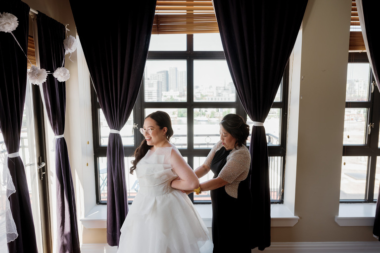 So excited for Erika and Andrei’s wedding day at The Box House Hotel in Brooklyn, NY. This boutique hotel had been on my bucket list for a while, and it did not disappoint! With its unique design, vibrant personality, and incredible rooftop views, The Box House Hotel provided the perfect setting for unique wedding celebration.
The day began with Erika and Andrei getting ready in their respective rooms, surrounded by friends and loved ones. One of the standout features of The Box House Hotel is its boutique charm and eclectic style, blending industrial elements with a cozy, artistic vibe. Erika’s bridal suite, with its floor-to-ceiling windows, was filled with natural light, making it a dream space for capturing those intimate getting-ready moments.
Once everyone was ready, Andrei headed to the rooftop, eagerly waiting to see his bride for the first time. As Erika gracefully approached, her dress swaying in the breeze, Andrei turned around, completely captivated. The two shared a private, heartfelt moment, whispering sweet words to each other, before we moved on to family photos.
The Box House Hotel’s location on a quiet Brooklyn street was perfect for photos. We captured their formal family and bridal party shots right in front of the hotel, showcasing its charming exterior. Then came a unique tradition I’d never witnessed before in my 14+ years of wedding photography! Erika and Andrei brought out a bucket of water filled with coins, and as guests cheered, Erika kicked the bucket as far as she could—a cultural ritual symbolizing good luck and prosperity. It was a joy to photograph and such a fun, memorable moment!
Afterward, we made our way back to the 10,000-square-foot rooftop, which offers unparalleled panoramic views of Manhattan, Brooklyn, and Long Island City. It’s a breathtaking setting for any wedding, leaving guests in awe of the skyline. Friends and family traveled from near and far, including Japan and Romania, to celebrate Erika and Andrei. To honor Erika's Japanese roots, Erika and Andrei incorporated a Japanese tea ceremony officiated by Erika's cousins from Japan. The rooftop was filled with laughter, love, and joy as the ceremony unfolded under the open sky.
As the sun set, the magic of the evening truly came alive. The city skyline twinkled with lights, and the dark sky sparkled with stars. Erika and Andrei danced, laughed, and celebrated late into the night, surrounded by their closest friends and family.
The Box House Hotel is a one-of-a-kind venue, blending urban sophistication with artistic charm. Its rooftop views, boutique-style accommodations, and vibrant atmosphere make it a perfect choice for couples looking to create a unique and unforgettable wedding experience.
Erika and Andrei, thank you for letting me be part of your incredible day. Wishing you a lifetime of love, happiness, and adventure!
Erika and Andrei The Box House Hotel Brooklyn NY Wedding documented by Karis from Hey Karis New York, Brooklyn, Hudson Valley NY and Catskills NY and NJ Wedding and NYC Elopement Photographer.