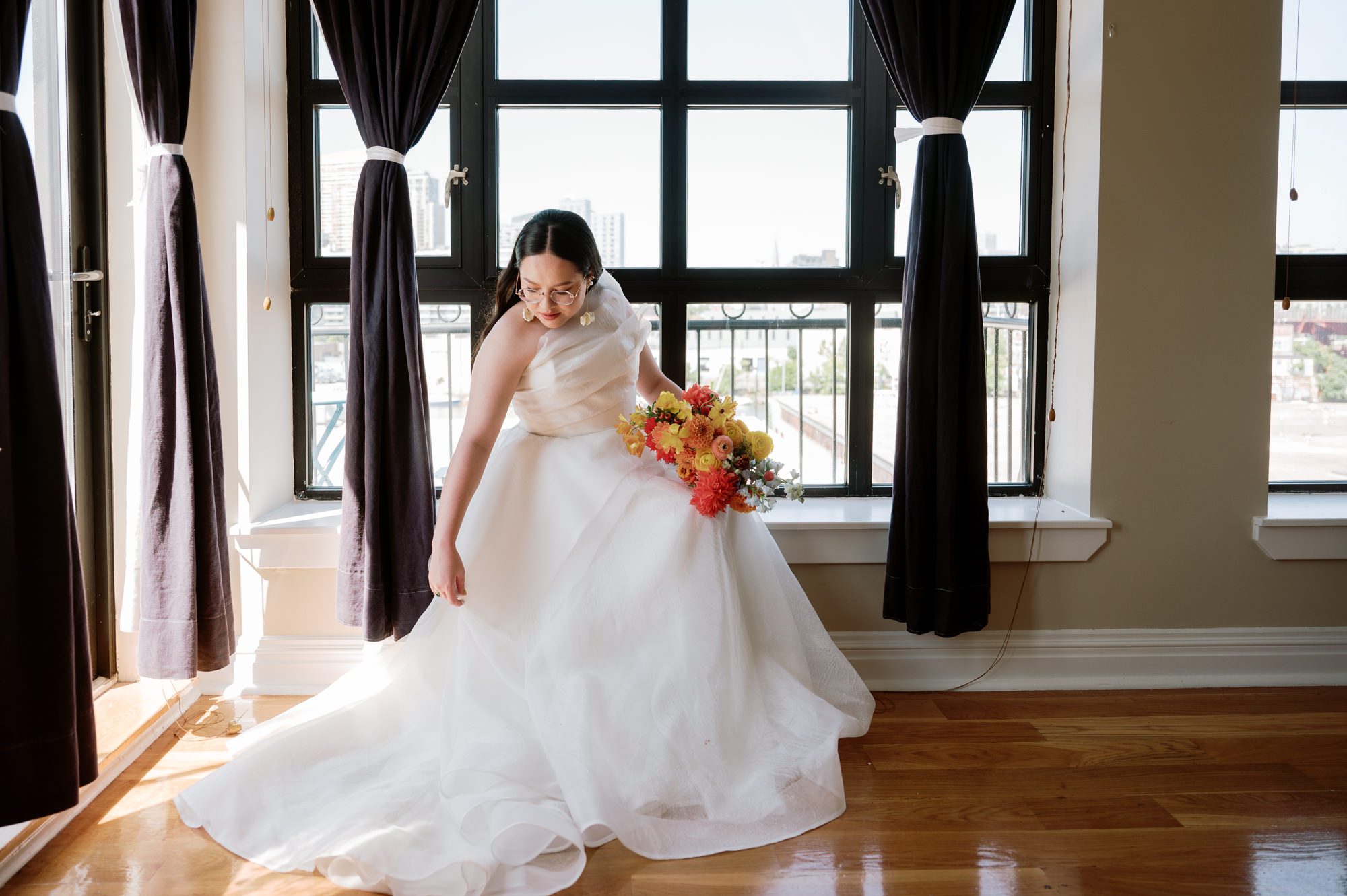 So excited for Erika and Andrei’s wedding day at The Box House Hotel in Brooklyn, NY. This boutique hotel had been on my bucket list for a while, and it did not disappoint! With its unique design, vibrant personality, and incredible rooftop views, The Box House Hotel provided the perfect setting for unique wedding celebration.
The day began with Erika and Andrei getting ready in their respective rooms, surrounded by friends and loved ones. One of the standout features of The Box House Hotel is its boutique charm and eclectic style, blending industrial elements with a cozy, artistic vibe. Erika’s bridal suite, with its floor-to-ceiling windows, was filled with natural light, making it a dream space for capturing those intimate getting-ready moments.
Once everyone was ready, Andrei headed to the rooftop, eagerly waiting to see his bride for the first time. As Erika gracefully approached, her dress swaying in the breeze, Andrei turned around, completely captivated. The two shared a private, heartfelt moment, whispering sweet words to each other, before we moved on to family photos.
The Box House Hotel’s location on a quiet Brooklyn street was perfect for photos. We captured their formal family and bridal party shots right in front of the hotel, showcasing its charming exterior. Then came a unique tradition I’d never witnessed before in my 14+ years of wedding photography! Erika and Andrei brought out a bucket of water filled with coins, and as guests cheered, Erika kicked the bucket as far as she could—a cultural ritual symbolizing good luck and prosperity. It was a joy to photograph and such a fun, memorable moment!
Afterward, we made our way back to the 10,000-square-foot rooftop, which offers unparalleled panoramic views of Manhattan, Brooklyn, and Long Island City. It’s a breathtaking setting for any wedding, leaving guests in awe of the skyline. Friends and family traveled from near and far, including Japan and Romania, to celebrate Erika and Andrei. To honor Erika's Japanese roots, Erika and Andrei incorporated a Japanese tea ceremony officiated by Erika's cousins from Japan. The rooftop was filled with laughter, love, and joy as the ceremony unfolded under the open sky.
As the sun set, the magic of the evening truly came alive. The city skyline twinkled with lights, and the dark sky sparkled with stars. Erika and Andrei danced, laughed, and celebrated late into the night, surrounded by their closest friends and family.
The Box House Hotel is a one-of-a-kind venue, blending urban sophistication with artistic charm. Its rooftop views, boutique-style accommodations, and vibrant atmosphere make it a perfect choice for couples looking to create a unique and unforgettable wedding experience.
Erika and Andrei, thank you for letting me be part of your incredible day. Wishing you a lifetime of love, happiness, and adventure!
Erika and Andrei The Box House Hotel Brooklyn NY Wedding documented by Karis from Hey Karis New York, Brooklyn, Hudson Valley NY and Catskills NY and NJ Wedding and NYC Elopement Photographer.