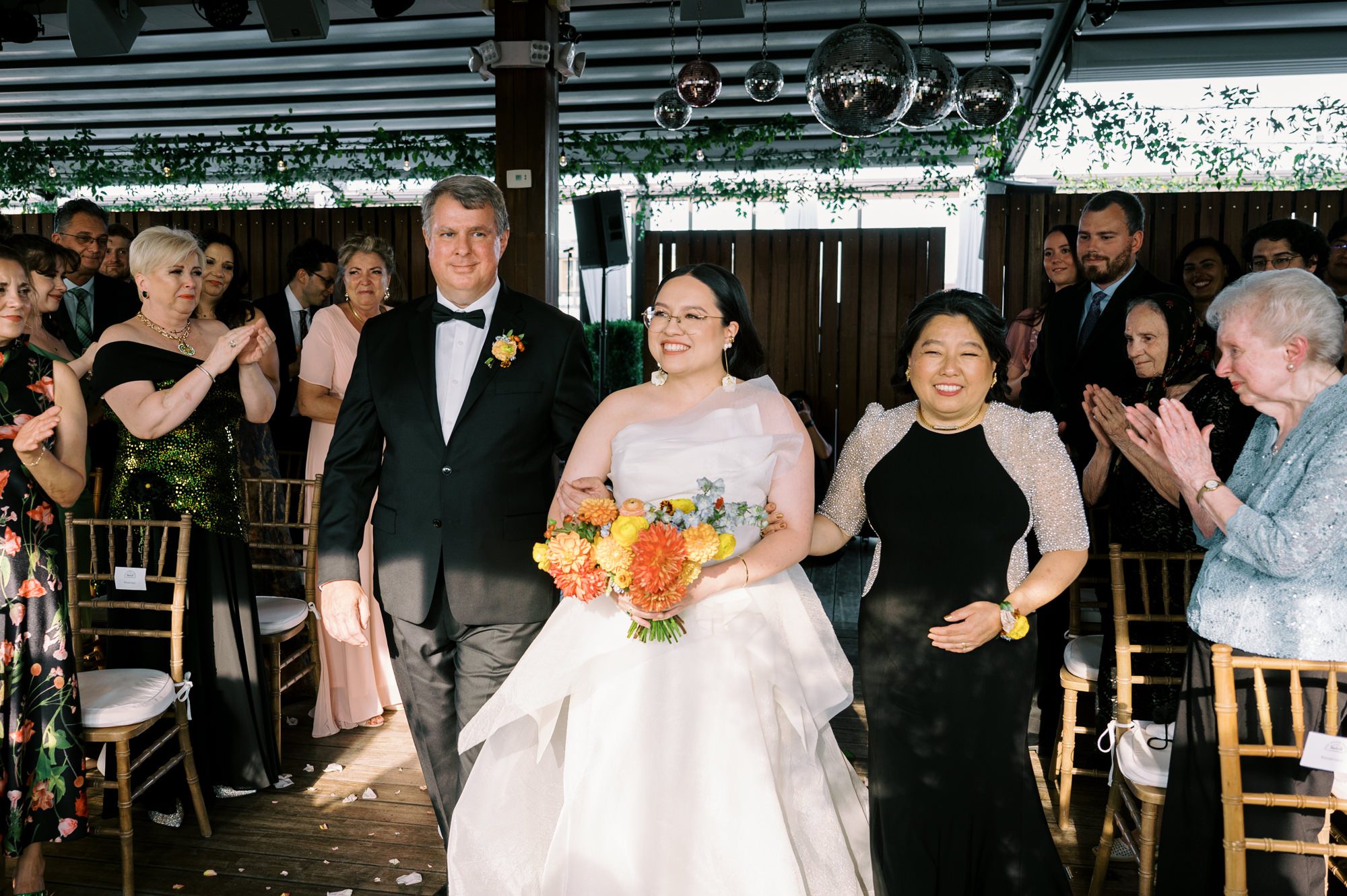 So excited for Erika and Andrei’s wedding day at The Box House Hotel in Brooklyn, NY. This boutique hotel had been on my bucket list for a while, and it did not disappoint! With its unique design, vibrant personality, and incredible rooftop views, The Box House Hotel provided the perfect setting for unique wedding celebration.
The day began with Erika and Andrei getting ready in their respective rooms, surrounded by friends and loved ones. One of the standout features of The Box House Hotel is its boutique charm and eclectic style, blending industrial elements with a cozy, artistic vibe. Erika’s bridal suite, with its floor-to-ceiling windows, was filled with natural light, making it a dream space for capturing those intimate getting-ready moments.
Once everyone was ready, Andrei headed to the rooftop, eagerly waiting to see his bride for the first time. As Erika gracefully approached, her dress swaying in the breeze, Andrei turned around, completely captivated. The two shared a private, heartfelt moment, whispering sweet words to each other, before we moved on to family photos.
The Box House Hotel’s location on a quiet Brooklyn street was perfect for photos. We captured their formal family and bridal party shots right in front of the hotel, showcasing its charming exterior. Then came a unique tradition I’d never witnessed before in my 14+ years of wedding photography! Erika and Andrei brought out a bucket of water filled with coins, and as guests cheered, Erika kicked the bucket as far as she could—a cultural ritual symbolizing good luck and prosperity. It was a joy to photograph and such a fun, memorable moment!
Afterward, we made our way back to the 10,000-square-foot rooftop, which offers unparalleled panoramic views of Manhattan, Brooklyn, and Long Island City. It’s a breathtaking setting for any wedding, leaving guests in awe of the skyline. Friends and family traveled from near and far, including Japan and Romania, to celebrate Erika and Andrei. To honor Erika's Japanese roots, Erika and Andrei incorporated a Japanese tea ceremony officiated by Erika's cousins from Japan. The rooftop was filled with laughter, love, and joy as the ceremony unfolded under the open sky.
As the sun set, the magic of the evening truly came alive. The city skyline twinkled with lights, and the dark sky sparkled with stars. Erika and Andrei danced, laughed, and celebrated late into the night, surrounded by their closest friends and family.
The Box House Hotel is a one-of-a-kind venue, blending urban sophistication with artistic charm. Its rooftop views, boutique-style accommodations, and vibrant atmosphere make it a perfect choice for couples looking to create a unique and unforgettable wedding experience.
Erika and Andrei, thank you for letting me be part of your incredible day. Wishing you a lifetime of love, happiness, and adventure!
Erika and Andrei The Box House Hotel Brooklyn NY Wedding documented by Karis from Hey Karis New York, Brooklyn, Hudson Valley NY and Catskills NY and NJ Wedding and NYC Elopement Photographer.