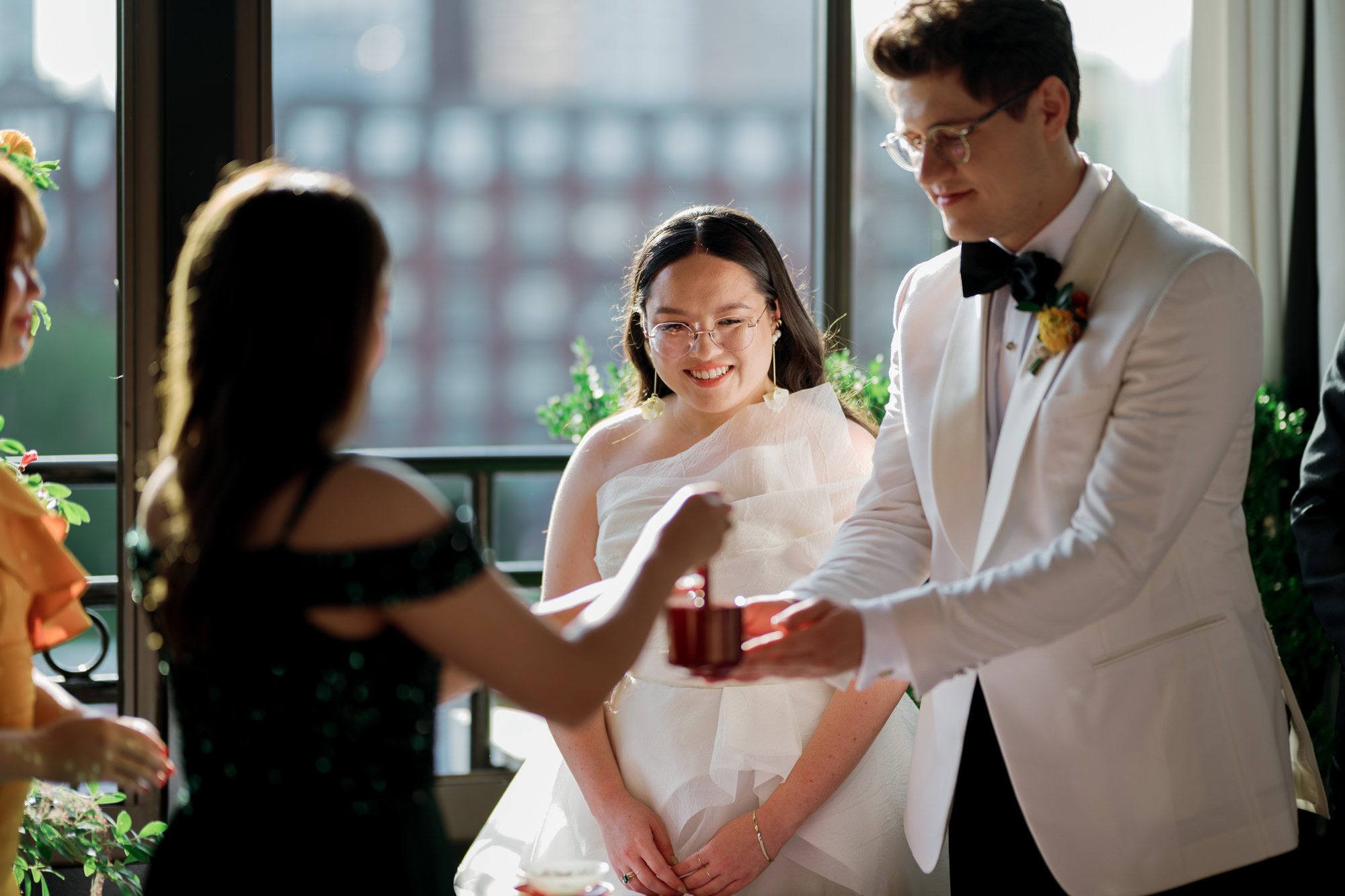 So excited for Erika and Andrei’s wedding day at The Box House Hotel in Brooklyn, NY. This boutique hotel had been on my bucket list for a while, and it did not disappoint! With its unique design, vibrant personality, and incredible rooftop views, The Box House Hotel provided the perfect setting for unique wedding celebration.
The day began with Erika and Andrei getting ready in their respective rooms, surrounded by friends and loved ones. One of the standout features of The Box House Hotel is its boutique charm and eclectic style, blending industrial elements with a cozy, artistic vibe. Erika’s bridal suite, with its floor-to-ceiling windows, was filled with natural light, making it a dream space for capturing those intimate getting-ready moments.
Once everyone was ready, Andrei headed to the rooftop, eagerly waiting to see his bride for the first time. As Erika gracefully approached, her dress swaying in the breeze, Andrei turned around, completely captivated. The two shared a private, heartfelt moment, whispering sweet words to each other, before we moved on to family photos.
The Box House Hotel’s location on a quiet Brooklyn street was perfect for photos. We captured their formal family and bridal party shots right in front of the hotel, showcasing its charming exterior. Then came a unique tradition I’d never witnessed before in my 14+ years of wedding photography! Erika and Andrei brought out a bucket of water filled with coins, and as guests cheered, Erika kicked the bucket as far as she could—a cultural ritual symbolizing good luck and prosperity. It was a joy to photograph and such a fun, memorable moment!
Afterward, we made our way back to the 10,000-square-foot rooftop, which offers unparalleled panoramic views of Manhattan, Brooklyn, and Long Island City. It’s a breathtaking setting for any wedding, leaving guests in awe of the skyline. Friends and family traveled from near and far, including Japan and Romania, to celebrate Erika and Andrei. To honor Erika's Japanese roots, Erika and Andrei incorporated a Japanese tea ceremony officiated by Erika's cousins from Japan. The rooftop was filled with laughter, love, and joy as the ceremony unfolded under the open sky.
As the sun set, the magic of the evening truly came alive. The city skyline twinkled with lights, and the dark sky sparkled with stars. Erika and Andrei danced, laughed, and celebrated late into the night, surrounded by their closest friends and family.
The Box House Hotel is a one-of-a-kind venue, blending urban sophistication with artistic charm. Its rooftop views, boutique-style accommodations, and vibrant atmosphere make it a perfect choice for couples looking to create a unique and unforgettable wedding experience.
Erika and Andrei, thank you for letting me be part of your incredible day. Wishing you a lifetime of love, happiness, and adventure!
Erika and Andrei The Box House Hotel Brooklyn NY Wedding documented by Karis from Hey Karis New York, Brooklyn, Hudson Valley NY and Catskills NY and NJ Wedding and NYC Elopement Photographer.