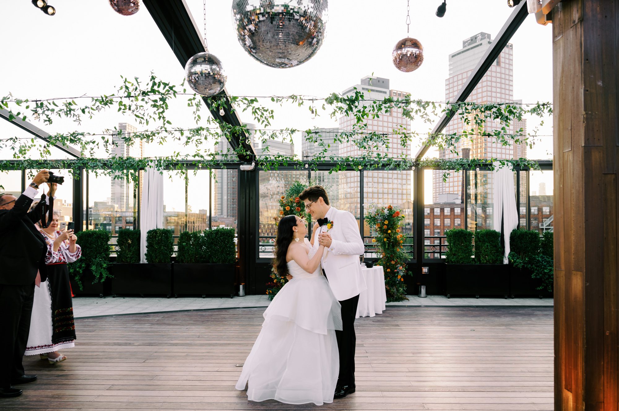 So excited for Erika and Andrei’s wedding day at The Box House Hotel in Brooklyn, NY. This boutique hotel had been on my bucket list for a while, and it did not disappoint! With its unique design, vibrant personality, and incredible rooftop views, The Box House Hotel provided the perfect setting for unique wedding celebration.
The day began with Erika and Andrei getting ready in their respective rooms, surrounded by friends and loved ones. One of the standout features of The Box House Hotel is its boutique charm and eclectic style, blending industrial elements with a cozy, artistic vibe. Erika’s bridal suite, with its floor-to-ceiling windows, was filled with natural light, making it a dream space for capturing those intimate getting-ready moments.
Once everyone was ready, Andrei headed to the rooftop, eagerly waiting to see his bride for the first time. As Erika gracefully approached, her dress swaying in the breeze, Andrei turned around, completely captivated. The two shared a private, heartfelt moment, whispering sweet words to each other, before we moved on to family photos.
The Box House Hotel’s location on a quiet Brooklyn street was perfect for photos. We captured their formal family and bridal party shots right in front of the hotel, showcasing its charming exterior. Then came a unique tradition I’d never witnessed before in my 14+ years of wedding photography! Erika and Andrei brought out a bucket of water filled with coins, and as guests cheered, Erika kicked the bucket as far as she could—a cultural ritual symbolizing good luck and prosperity. It was a joy to photograph and such a fun, memorable moment!
Afterward, we made our way back to the 10,000-square-foot rooftop, which offers unparalleled panoramic views of Manhattan, Brooklyn, and Long Island City. It’s a breathtaking setting for any wedding, leaving guests in awe of the skyline. Friends and family traveled from near and far, including Japan and Romania, to celebrate Erika and Andrei. To honor Erika's Japanese roots, Erika and Andrei incorporated a Japanese tea ceremony officiated by Erika's cousins from Japan. The rooftop was filled with laughter, love, and joy as the ceremony unfolded under the open sky.
As the sun set, the magic of the evening truly came alive. The city skyline twinkled with lights, and the dark sky sparkled with stars. Erika and Andrei danced, laughed, and celebrated late into the night, surrounded by their closest friends and family.
The Box House Hotel is a one-of-a-kind venue, blending urban sophistication with artistic charm. Its rooftop views, boutique-style accommodations, and vibrant atmosphere make it a perfect choice for couples looking to create a unique and unforgettable wedding experience.
Erika and Andrei, thank you for letting me be part of your incredible day. Wishing you a lifetime of love, happiness, and adventure!
Erika and Andrei The Box House Hotel Brooklyn NY Wedding documented by Karis from Hey Karis New York, Brooklyn, Hudson Valley NY and Catskills NY and NJ Wedding and NYC Elopement Photographer.