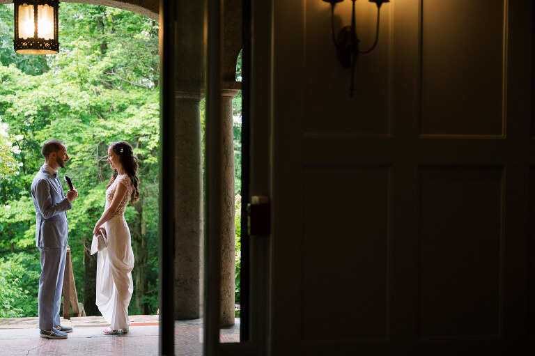 Driving up the long, tree-lined driveway to Arrow Park is a magical experience. No matter how many times you see it, the peaceful serenity of the surroundings leaves you in awe. On Willa and Alex’s wedding day, the forecast called for heavy overcast skies, which only made the lush greenery more vibrant. As I approached the historic mansion, a light rain began to fall, making the natural landscape look even more alive and enchanting.
Inside the mansion, the atmosphere was festive and filled with excitement. I spotted Alex bustling around, finishing some light tasks with a mix of nervous energy and anticipation. On the third floor, I found Willa glowing with happiness as she admired herself in the mirror in her wedding dress. After her final look, Willa gracefully descended the grand staircase to the terrace, where Alex was waiting for their first look.
Despite the gentle drizzle, the terrace offered the perfect backdrop for this intimate moment. Framed by Arrow Park’s lush greenery and timeless charm, Willa and Alex exchanged private vows. It was a sweet, emotional moment, just the two of them, soaking in the beauty of the day before heading back into the mansion.
Arrow Park, with its 1920s-era mansion, sprawling grounds, and serene lakefront, is a venue that seamlessly combines natural beauty with historical elegance. It’s a place that feels worlds away while still being accessible, making it ideal for couples who want a tranquil yet sophisticated setting for their wedding day.
Willa and Alex wanted their wedding to focus on spending quality time with their loved ones rather than being tied to posed portraits. As a result, nearly the entire day was filled with organic, documentary-style moments that were both refreshing and liberating to capture.
Their Jewish ceremony was held on the terrace, with Arrow Park’s picturesque grounds as the backdrop. One of the most unique elements of their ceremony was the participation of friends and family in the Seven Blessings, a beautiful and meaningful tradition that added a personal touch to their day.
During cocktail hour, Willa and Alex mingled effortlessly with their guests, catching up with family and friends they hadn’t seen in some time. Afterward, the celebration moved to the rustic lodge, a space that perfectly complements Arrow Park’s vintage charm. The lodge was alive with dancing, singing, and laughter as Willa and Alex celebrated the start of their new chapter, surrounded by their closest family and friends.
Willa and Alex’s wedding at Arrow Park was a day filled with love, joy, and meaningful connections. It was an honor to document such a heartfelt celebration in one of the most breathtaking venues in New York. Congratulations, Willa and Alex!
Willa and Alex Arrow Park NY Wedding documented by Karis from Hey Karis New York, Brooklyn, Hudson Valley NY and Catskills NY and NJ Wedding and NYC Elopement Photographer.
