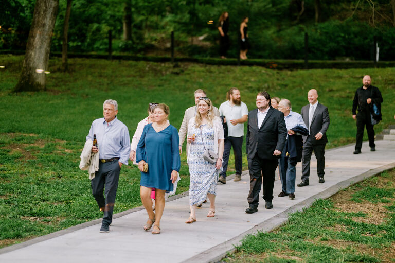 Driving up the long, tree-lined driveway to Arrow Park is a magical experience. No matter how many times you see it, the peaceful serenity of the surroundings leaves you in awe. On Willa and Alex’s wedding day, the forecast called for heavy overcast skies, which only made the lush greenery more vibrant. As I approached the historic mansion, a light rain began to fall, making the natural landscape look even more alive and enchanting.
Inside the mansion, the atmosphere was festive and filled with excitement. I spotted Alex bustling around, finishing some light tasks with a mix of nervous energy and anticipation. On the third floor, I found Willa glowing with happiness as she admired herself in the mirror in her wedding dress. After her final look, Willa gracefully descended the grand staircase to the terrace, where Alex was waiting for their first look.
Despite the gentle drizzle, the terrace offered the perfect backdrop for this intimate moment. Framed by Arrow Park’s lush greenery and timeless charm, Willa and Alex exchanged private vows. It was a sweet, emotional moment, just the two of them, soaking in the beauty of the day before heading back into the mansion.
Arrow Park, with its 1920s-era mansion, sprawling grounds, and serene lakefront, is a venue that seamlessly combines natural beauty with historical elegance. It’s a place that feels worlds away while still being accessible, making it ideal for couples who want a tranquil yet sophisticated setting for their wedding day.
Willa and Alex wanted their wedding to focus on spending quality time with their loved ones rather than being tied to posed portraits. As a result, nearly the entire day was filled with organic, documentary-style moments that were both refreshing and liberating to capture.
Their Jewish ceremony was held on the terrace, with Arrow Park’s picturesque grounds as the backdrop. One of the most unique elements of their ceremony was the participation of friends and family in the Seven Blessings, a beautiful and meaningful tradition that added a personal touch to their day.
During cocktail hour, Willa and Alex mingled effortlessly with their guests, catching up with family and friends they hadn’t seen in some time. Afterward, the celebration moved to the rustic lodge, a space that perfectly complements Arrow Park’s vintage charm. The lodge was alive with dancing, singing, and laughter as Willa and Alex celebrated the start of their new chapter, surrounded by their closest family and friends.
Willa and Alex’s wedding at Arrow Park was a day filled with love, joy, and meaningful connections. It was an honor to document such a heartfelt celebration in one of the most breathtaking venues in New York. Congratulations, Willa and Alex!
Willa and Alex Arrow Park NY Wedding documented by Karis from Hey Karis New York, Brooklyn, Hudson Valley NY and Catskills NY and NJ Wedding and NYC Elopement Photographer.

