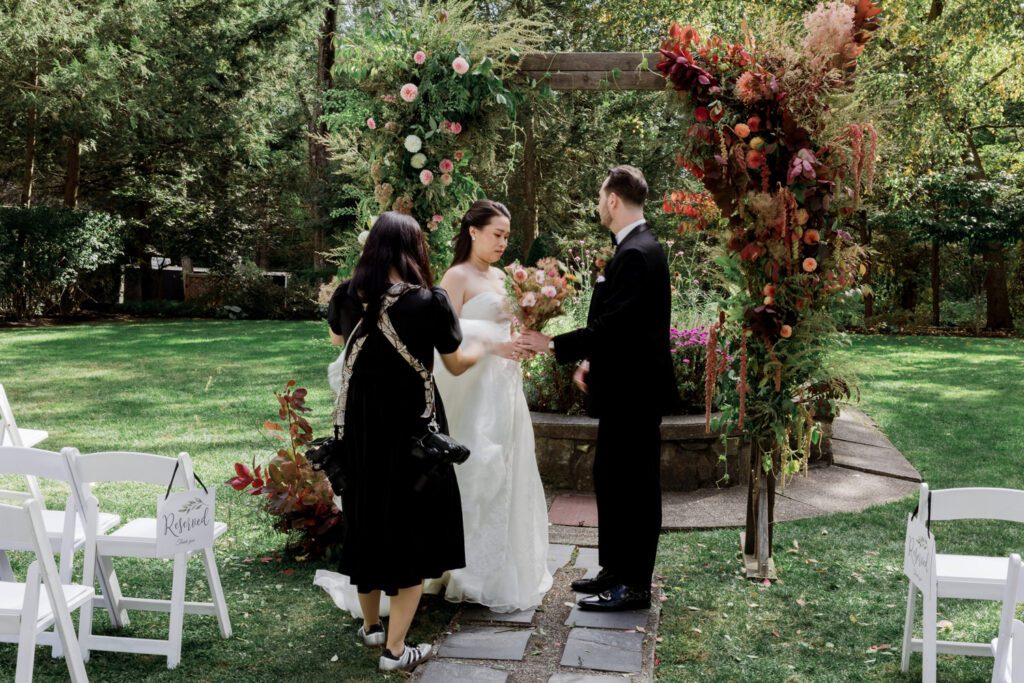 Vivian and Josh’s Gorgeous September Wedding at Arrow Park, NY
There’s something truly special about Arrow Park—it feels like my home away from home, and Vivian and Josh’s beautiful September wedding perfectly showcased everything this venue has to offer. Their blended celebration, honoring Vivian’s Korean heritage and Josh’s Jewish background, was a heartfelt and unforgettable day.
The couple beautifully wove their cultures into the festivities, from breaking the glass at the end of their garden ceremony to the lively horah during the reception. Later, Vivian and Josh delighted their guests by changing into traditional Korean hanbok outfits, a touching nod to her heritage.
Arrow Park: A Dream Venue for Multi-Day WeddingsVivian, Josh, and their loved ones all got ready at Arrow Park, which offers plenty of spacious accommodations for family and friends. This made it the perfect choice for their multi-day celebration. With its stunning grounds and versatile spaces, Arrow Park is ideal for couples seeking a wedding weekend filled with both elegance and comfort.
A Scenic September CelebrationThanks to the pleasant September weather, Vivian and Josh made full use of Arrow Park’s breathtaking grounds. Their day began with a magical first look along the iconic driveway lined with towering trees. From there, we explored the garden with its charming sculptures, captured moments by the ceremony’s floral décor, and took stunning portraits on the mansion’s iconic back staircase bathed in perfect lighting. We also ventured indoors for photos in the library and the Green Room, taking advantage of the mansion’s timeless charm.
As family and friends gathered, we captured formal portraits in front of the grand mansion before the ceremony began.
A Ceremony and Reception to RememberThe ceremony was set in the picturesque garden, where Jenny from Field Trip Flowers created a breathtaking floral backdrop that perfectly complemented the natural beauty of Arrow Park.
Afterward, guests strolled back to the mansion for a warm and inviting cocktail hour on the main floor. Later, everyone gathered in the courtyard for an enchanting outdoor reception under twinkling café lights. The space felt intimate yet grand, with the perfect blend of rustic elegance and romance.
Arrow Park’s charm, coupled with Vivian and Josh’s thoughtful cultural details, made this wedding one to remember. It’s the kind of venue where dreams come true—a hidden gem that’s ready to host your perfect day.
  
Thankful for all the wedding vendors that made this day possible:⁠
Venue: @arrowparkny
Floral: @fieldtripflowers
Catering: @lovenrosemary

Vivian and Josh Arrow Park NY Wedding documented by Karis from Hey Karis New York, Brooklyn, Hudson Valley NY and Catskills NY and NJ Wedding and NYC Elopement Photographer.
