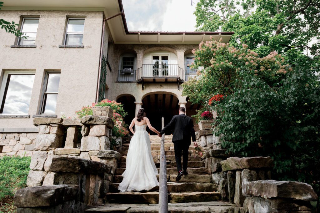 Vivian and Josh’s Gorgeous September Wedding at Arrow Park, NY
There’s something truly special about Arrow Park—it feels like my home away from home, and Vivian and Josh’s beautiful September wedding perfectly showcased everything this venue has to offer. Their blended celebration, honoring Vivian’s Korean heritage and Josh’s Jewish background, was a heartfelt and unforgettable day.
The couple beautifully wove their cultures into the festivities, from breaking the glass at the end of their garden ceremony to the lively horah during the reception. Later, Vivian and Josh delighted their guests by changing into traditional Korean hanbok outfits, a touching nod to her heritage.
Arrow Park: A Dream Venue for Multi-Day WeddingsVivian, Josh, and their loved ones all got ready at Arrow Park, which offers plenty of spacious accommodations for family and friends. This made it the perfect choice for their multi-day celebration. With its stunning grounds and versatile spaces, Arrow Park is ideal for couples seeking a wedding weekend filled with both elegance and comfort.
A Scenic September CelebrationThanks to the pleasant September weather, Vivian and Josh made full use of Arrow Park’s breathtaking grounds. Their day began with a magical first look along the iconic driveway lined with towering trees. From there, we explored the garden with its charming sculptures, captured moments by the ceremony’s floral décor, and took stunning portraits on the mansion’s iconic back staircase bathed in perfect lighting. We also ventured indoors for photos in the library and the Green Room, taking advantage of the mansion’s timeless charm.
As family and friends gathered, we captured formal portraits in front of the grand mansion before the ceremony began.
A Ceremony and Reception to RememberThe ceremony was set in the picturesque garden, where Jenny from Field Trip Flowers created a breathtaking floral backdrop that perfectly complemented the natural beauty of Arrow Park.
Afterward, guests strolled back to the mansion for a warm and inviting cocktail hour on the main floor. Later, everyone gathered in the courtyard for an enchanting outdoor reception under twinkling café lights. The space felt intimate yet grand, with the perfect blend of rustic elegance and romance.
Arrow Park’s charm, coupled with Vivian and Josh’s thoughtful cultural details, made this wedding one to remember. It’s the kind of venue where dreams come true—a hidden gem that’s ready to host your perfect day.
  
Thankful for all the wedding vendors that made this day possible:⁠
Venue: @arrowparkny
Floral: @fieldtripflowers
Catering: @lovenrosemary

Vivian and Josh Arrow Park NY Wedding documented by Karis from Hey Karis New York, Brooklyn, Hudson Valley NY and Catskills NY and NJ Wedding and NYC Elopement Photographer.