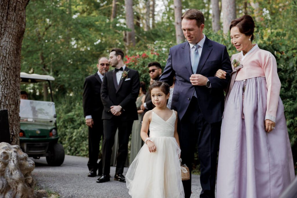 Vivian and Josh’s Gorgeous September Wedding at Arrow Park, NY
There’s something truly special about Arrow Park—it feels like my home away from home, and Vivian and Josh’s beautiful September wedding perfectly showcased everything this venue has to offer. Their blended celebration, honoring Vivian’s Korean heritage and Josh’s Jewish background, was a heartfelt and unforgettable day.
The couple beautifully wove their cultures into the festivities, from breaking the glass at the end of their garden ceremony to the lively horah during the reception. Later, Vivian and Josh delighted their guests by changing into traditional Korean hanbok outfits, a touching nod to her heritage.
Arrow Park: A Dream Venue for Multi-Day WeddingsVivian, Josh, and their loved ones all got ready at Arrow Park, which offers plenty of spacious accommodations for family and friends. This made it the perfect choice for their multi-day celebration. With its stunning grounds and versatile spaces, Arrow Park is ideal for couples seeking a wedding weekend filled with both elegance and comfort.
A Scenic September CelebrationThanks to the pleasant September weather, Vivian and Josh made full use of Arrow Park’s breathtaking grounds. Their day began with a magical first look along the iconic driveway lined with towering trees. From there, we explored the garden with its charming sculptures, captured moments by the ceremony’s floral décor, and took stunning portraits on the mansion’s iconic back staircase bathed in perfect lighting. We also ventured indoors for photos in the library and the Green Room, taking advantage of the mansion’s timeless charm.
As family and friends gathered, we captured formal portraits in front of the grand mansion before the ceremony began.
A Ceremony and Reception to RememberThe ceremony was set in the picturesque garden, where Jenny from Field Trip Flowers created a breathtaking floral backdrop that perfectly complemented the natural beauty of Arrow Park.
Afterward, guests strolled back to the mansion for a warm and inviting cocktail hour on the main floor. Later, everyone gathered in the courtyard for an enchanting outdoor reception under twinkling café lights. The space felt intimate yet grand, with the perfect blend of rustic elegance and romance.
Arrow Park’s charm, coupled with Vivian and Josh’s thoughtful cultural details, made this wedding one to remember. It’s the kind of venue where dreams come true—a hidden gem that’s ready to host your perfect day.
  
Thankful for all the wedding vendors that made this day possible:⁠
Venue: @arrowparkny
Floral: @fieldtripflowers
Catering: @lovenrosemary

Vivian and Josh Arrow Park NY Wedding documented by Karis from Hey Karis New York, Brooklyn, Hudson Valley NY and Catskills NY and NJ Wedding and NYC Elopement Photographer.