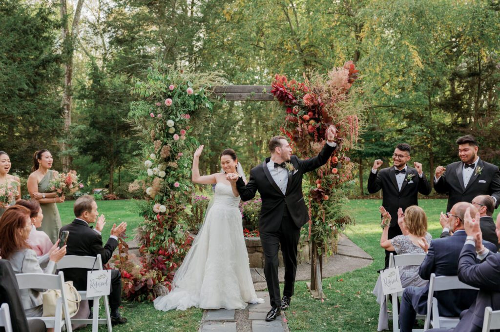 Vivian and Josh’s Gorgeous September Wedding at Arrow Park, NY
There’s something truly special about Arrow Park—it feels like my home away from home, and Vivian and Josh’s beautiful September wedding perfectly showcased everything this venue has to offer. Their blended celebration, honoring Vivian’s Korean heritage and Josh’s Jewish background, was a heartfelt and unforgettable day.
The couple beautifully wove their cultures into the festivities, from breaking the glass at the end of their garden ceremony to the lively horah during the reception. Later, Vivian and Josh delighted their guests by changing into traditional Korean hanbok outfits, a touching nod to her heritage.
Arrow Park: A Dream Venue for Multi-Day WeddingsVivian, Josh, and their loved ones all got ready at Arrow Park, which offers plenty of spacious accommodations for family and friends. This made it the perfect choice for their multi-day celebration. With its stunning grounds and versatile spaces, Arrow Park is ideal for couples seeking a wedding weekend filled with both elegance and comfort.
A Scenic September CelebrationThanks to the pleasant September weather, Vivian and Josh made full use of Arrow Park’s breathtaking grounds. Their day began with a magical first look along the iconic driveway lined with towering trees. From there, we explored the garden with its charming sculptures, captured moments by the ceremony’s floral décor, and took stunning portraits on the mansion’s iconic back staircase bathed in perfect lighting. We also ventured indoors for photos in the library and the Green Room, taking advantage of the mansion’s timeless charm.
As family and friends gathered, we captured formal portraits in front of the grand mansion before the ceremony began.
A Ceremony and Reception to RememberThe ceremony was set in the picturesque garden, where Jenny from Field Trip Flowers created a breathtaking floral backdrop that perfectly complemented the natural beauty of Arrow Park.
Afterward, guests strolled back to the mansion for a warm and inviting cocktail hour on the main floor. Later, everyone gathered in the courtyard for an enchanting outdoor reception under twinkling café lights. The space felt intimate yet grand, with the perfect blend of rustic elegance and romance.
Arrow Park’s charm, coupled with Vivian and Josh’s thoughtful cultural details, made this wedding one to remember. It’s the kind of venue where dreams come true—a hidden gem that’s ready to host your perfect day.
  
Thankful for all the wedding vendors that made this day possible:⁠
Venue: @arrowparkny
Floral: @fieldtripflowers
Catering: @lovenrosemary

Vivian and Josh Arrow Park NY Wedding documented by Karis from Hey Karis New York, Brooklyn, Hudson Valley NY and Catskills NY and NJ Wedding and NYC Elopement Photographer.