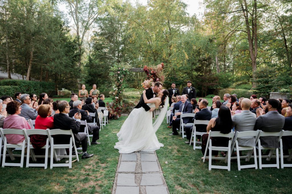Vivian and Josh’s Gorgeous September Wedding at Arrow Park, NY
There’s something truly special about Arrow Park—it feels like my home away from home, and Vivian and Josh’s beautiful September wedding perfectly showcased everything this venue has to offer. Their blended celebration, honoring Vivian’s Korean heritage and Josh’s Jewish background, was a heartfelt and unforgettable day.
The couple beautifully wove their cultures into the festivities, from breaking the glass at the end of their garden ceremony to the lively horah during the reception. Later, Vivian and Josh delighted their guests by changing into traditional Korean hanbok outfits, a touching nod to her heritage.
Arrow Park: A Dream Venue for Multi-Day WeddingsVivian, Josh, and their loved ones all got ready at Arrow Park, which offers plenty of spacious accommodations for family and friends. This made it the perfect choice for their multi-day celebration. With its stunning grounds and versatile spaces, Arrow Park is ideal for couples seeking a wedding weekend filled with both elegance and comfort.
A Scenic September CelebrationThanks to the pleasant September weather, Vivian and Josh made full use of Arrow Park’s breathtaking grounds. Their day began with a magical first look along the iconic driveway lined with towering trees. From there, we explored the garden with its charming sculptures, captured moments by the ceremony’s floral décor, and took stunning portraits on the mansion’s iconic back staircase bathed in perfect lighting. We also ventured indoors for photos in the library and the Green Room, taking advantage of the mansion’s timeless charm.
As family and friends gathered, we captured formal portraits in front of the grand mansion before the ceremony began.
A Ceremony and Reception to RememberThe ceremony was set in the picturesque garden, where Jenny from Field Trip Flowers created a breathtaking floral backdrop that perfectly complemented the natural beauty of Arrow Park.
Afterward, guests strolled back to the mansion for a warm and inviting cocktail hour on the main floor. Later, everyone gathered in the courtyard for an enchanting outdoor reception under twinkling café lights. The space felt intimate yet grand, with the perfect blend of rustic elegance and romance.
Arrow Park’s charm, coupled with Vivian and Josh’s thoughtful cultural details, made this wedding one to remember. It’s the kind of venue where dreams come true—a hidden gem that’s ready to host your perfect day.
  
Thankful for all the wedding vendors that made this day possible:⁠
Venue: @arrowparkny
Floral: @fieldtripflowers

Vivian and Josh Arrow Park NY Wedding documented by Karis from Hey Karis New York, Brooklyn, Hudson Valley NY and Catskills NY and NJ Wedding and NYC Elopement Photographer.
