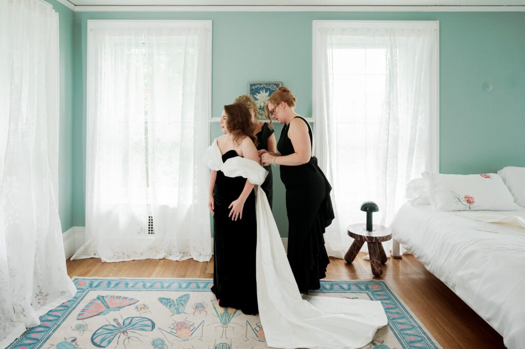 Kirsten and AJ’s September Wedding at Arrow Park, NY
Kirsten and AJ’s wedding day was a bit chilly and rainy, but their flexibility and positivity turned the day into a magical celebration. Originally planned for the garden, the ceremony was moved indoors due to the autumn rain. The staff at Arrow Park seamlessly transitioned the setup to the mansion’s main floor, creating an intimate and elegant ceremony space. The historic charm of the mansion, with its grand details and warm ambiance, added a cozy, romantic touch to their special day.
Kirsten, a talented fashion designer, surprised everyone—including her groom, AJ—by wearing a stunning black velvet strapless dress with an oversized white bow draping dramatically down the back. She designed the dress herself, and it was a show-stopper that perfectly reflected her unique style. The ceremony was heartfelt and personal, with family and friends gathering close to witness Kirsten and AJ’s vows.
After the ceremony, the main mansion was transformed to host a lively cocktail hour. Guests mingled and enjoyed delicious hors d'oeuvres while the reception space in the pavilion was being prepared. Kirsten and AJ’s attention to detail shone through in their décor choices, including the black-and-white checkered flooring that gave the pavilion a retro vibe. It was a perfect blend of modern chic and classic sophistication.
The reception began with Kirsten and AJ’s grand entrance, greeted by cheers from their guests. Their first dance was sweet and endearing, setting the tone for a night of joy and celebration. As the evening progressed, the party ramped up with enthusiastic dancing, heartfelt toasts, and even a surprise performance—a few uncles took the mic for an impromptu rap song that brought the house down.
Arrow Park provided the perfect backdrop for Kirsten and AJ’s wedding. With its blend of natural beauty and historic architecture, it’s an ideal venue for couples seeking a mix of indoor and outdoor spaces. The mansion offers a timeless elegance, while the pavilion provides a versatile setting for larger receptions.
Planning Tips for Future Couples at Arrow Park:
1. Have a Rain Plan: September weather can be unpredictable, so work with the Arrow Park staff to plan for both indoor and outdoor options. The mansion’s interiors provide a stunning alternative for ceremonies or cocktail hours.
2. Maximize the Pavilion: The pavilion’s spacious layout can accommodate various themes and setups. Consider unique flooring, lighting, or drapery to make the space your own.
3. Embrace the Venue’s Charm: Use the mansion’s historic features—like the fireplaces and vintage decor—as part of your wedding aesthetic. It’s a built-in backdrop that needs little embellishment.
4. Plan Time for Photos: Arrow Park’s grounds are breathtaking, especially in the fall. Schedule time with your photographer to capture the beauty of the lake, gardens, and mansion.
Kirsten and AJ’s wedding was a true testament to the power of creativity, adaptability, and love. Their celebration at Arrow Park was unforgettable, and I’m grateful to have been a part of their special day.
Thankful for all the wedding vendors that made this day possible:⁠
Venue: @arrowparkny
Catering: @lovenrosemary
Kirsten and AJ Arrow Park NY Wedding documented by Karis from Hey Karis New York, Brooklyn, Hudson Valley NY and Catskills NY and NJ Wedding and NYC Elopement Photographer.