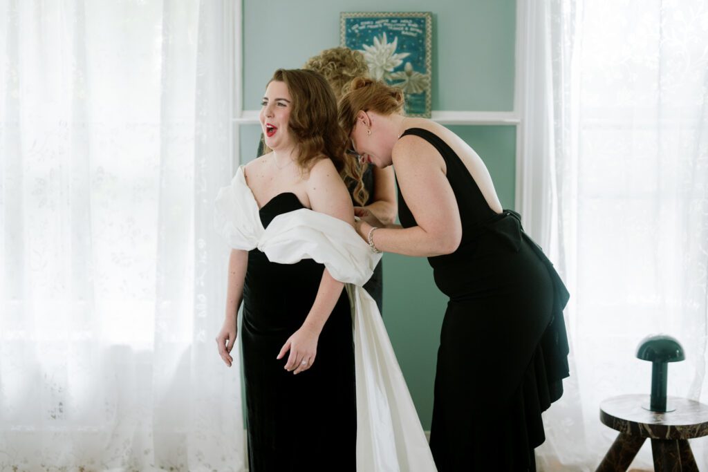 Kirsten and AJ’s September Wedding at Arrow Park, NY
Kirsten and AJ’s wedding day was a bit chilly and rainy, but their flexibility and positivity turned the day into a magical celebration. Originally planned for the garden, the ceremony was moved indoors due to the autumn rain. The staff at Arrow Park seamlessly transitioned the setup to the mansion’s main floor, creating an intimate and elegant ceremony space. The historic charm of the mansion, with its grand details and warm ambiance, added a cozy, romantic touch to their special day.
Kirsten, a talented fashion designer, surprised everyone—including her groom, AJ—by wearing a stunning black velvet strapless dress with an oversized white bow draping dramatically down the back. She designed the dress herself, and it was a show-stopper that perfectly reflected her unique style. The ceremony was heartfelt and personal, with family and friends gathering close to witness Kirsten and AJ’s vows.
After the ceremony, the main mansion was transformed to host a lively cocktail hour. Guests mingled and enjoyed delicious hors d'oeuvres while the reception space in the pavilion was being prepared. Kirsten and AJ’s attention to detail shone through in their décor choices, including the black-and-white checkered flooring that gave the pavilion a retro vibe. It was a perfect blend of modern chic and classic sophistication.
The reception began with Kirsten and AJ’s grand entrance, greeted by cheers from their guests. Their first dance was sweet and endearing, setting the tone for a night of joy and celebration. As the evening progressed, the party ramped up with enthusiastic dancing, heartfelt toasts, and even a surprise performance—a few uncles took the mic for an impromptu rap song that brought the house down.
Arrow Park provided the perfect backdrop for Kirsten and AJ’s wedding. With its blend of natural beauty and historic architecture, it’s an ideal venue for couples seeking a mix of indoor and outdoor spaces. The mansion offers a timeless elegance, while the pavilion provides a versatile setting for larger receptions.
Planning Tips for Future Couples at Arrow Park:
1. Have a Rain Plan: September weather can be unpredictable, so work with the Arrow Park staff to plan for both indoor and outdoor options. The mansion’s interiors provide a stunning alternative for ceremonies or cocktail hours.
2. Maximize the Pavilion: The pavilion’s spacious layout can accommodate various themes and setups. Consider unique flooring, lighting, or drapery to make the space your own.
3. Embrace the Venue’s Charm: Use the mansion’s historic features—like the fireplaces and vintage decor—as part of your wedding aesthetic. It’s a built-in backdrop that needs little embellishment.
4. Plan Time for Photos: Arrow Park’s grounds are breathtaking, especially in the fall. Schedule time with your photographer to capture the beauty of the lake, gardens, and mansion.
Kirsten and AJ’s wedding was a true testament to the power of creativity, adaptability, and love. Their celebration at Arrow Park was unforgettable, and I’m grateful to have been a part of their special day.
Thankful for all the wedding vendors that made this day possible:⁠
Venue: @arrowparkny
Catering: @lovenrosemary
Kirsten and AJ Arrow Park NY Wedding documented by Karis from Hey Karis New York, Brooklyn, Hudson Valley NY and Catskills NY and NJ Wedding and NYC Elopement Photographer.