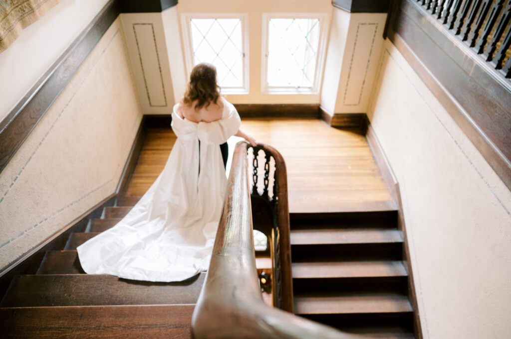 Kirsten and AJ’s September Wedding at Arrow Park, NY
Kirsten and AJ’s wedding day was a bit chilly and rainy, but their flexibility and positivity turned the day into a magical celebration. Originally planned for the garden, the ceremony was moved indoors due to the autumn rain. The staff at Arrow Park seamlessly transitioned the setup to the mansion’s main floor, creating an intimate and elegant ceremony space. The historic charm of the mansion, with its grand details and warm ambiance, added a cozy, romantic touch to their special day.
Kirsten, a talented fashion designer, surprised everyone—including her groom, AJ—by wearing a stunning black velvet strapless dress with an oversized white bow draping dramatically down the back. She designed the dress herself, and it was a show-stopper that perfectly reflected her unique style. The ceremony was heartfelt and personal, with family and friends gathering close to witness Kirsten and AJ’s vows.
After the ceremony, the main mansion was transformed to host a lively cocktail hour. Guests mingled and enjoyed delicious hors d'oeuvres while the reception space in the pavilion was being prepared. Kirsten and AJ’s attention to detail shone through in their décor choices, including the black-and-white checkered flooring that gave the pavilion a retro vibe. It was a perfect blend of modern chic and classic sophistication.
The reception began with Kirsten and AJ’s grand entrance, greeted by cheers from their guests. Their first dance was sweet and endearing, setting the tone for a night of joy and celebration. As the evening progressed, the party ramped up with enthusiastic dancing, heartfelt toasts, and even a surprise performance—a few uncles took the mic for an impromptu rap song that brought the house down.
Arrow Park provided the perfect backdrop for Kirsten and AJ’s wedding. With its blend of natural beauty and historic architecture, it’s an ideal venue for couples seeking a mix of indoor and outdoor spaces. The mansion offers a timeless elegance, while the pavilion provides a versatile setting for larger receptions.
Planning Tips for Future Couples at Arrow Park:
1. Have a Rain Plan: September weather can be unpredictable, so work with the Arrow Park staff to plan for both indoor and outdoor options. The mansion’s interiors provide a stunning alternative for ceremonies or cocktail hours.
2. Maximize the Pavilion: The pavilion’s spacious layout can accommodate various themes and setups. Consider unique flooring, lighting, or drapery to make the space your own.
3. Embrace the Venue’s Charm: Use the mansion’s historic features—like the fireplaces and vintage decor—as part of your wedding aesthetic. It’s a built-in backdrop that needs little embellishment.
4. Plan Time for Photos: Arrow Park’s grounds are breathtaking, especially in the fall. Schedule time with your photographer to capture the beauty of the lake, gardens, and mansion.
Kirsten and AJ’s wedding was a true testament to the power of creativity, adaptability, and love. Their celebration at Arrow Park was unforgettable, and I’m grateful to have been a part of their special day.
Thankful for all the wedding vendors that made this day possible:⁠
Venue: @arrowparkny
Catering: @lovenrosemary
Kirsten and AJ Arrow Park NY Wedding documented by Karis from Hey Karis New York, Brooklyn, Hudson Valley NY and Catskills NY and NJ Wedding and NYC Elopement Photographer.