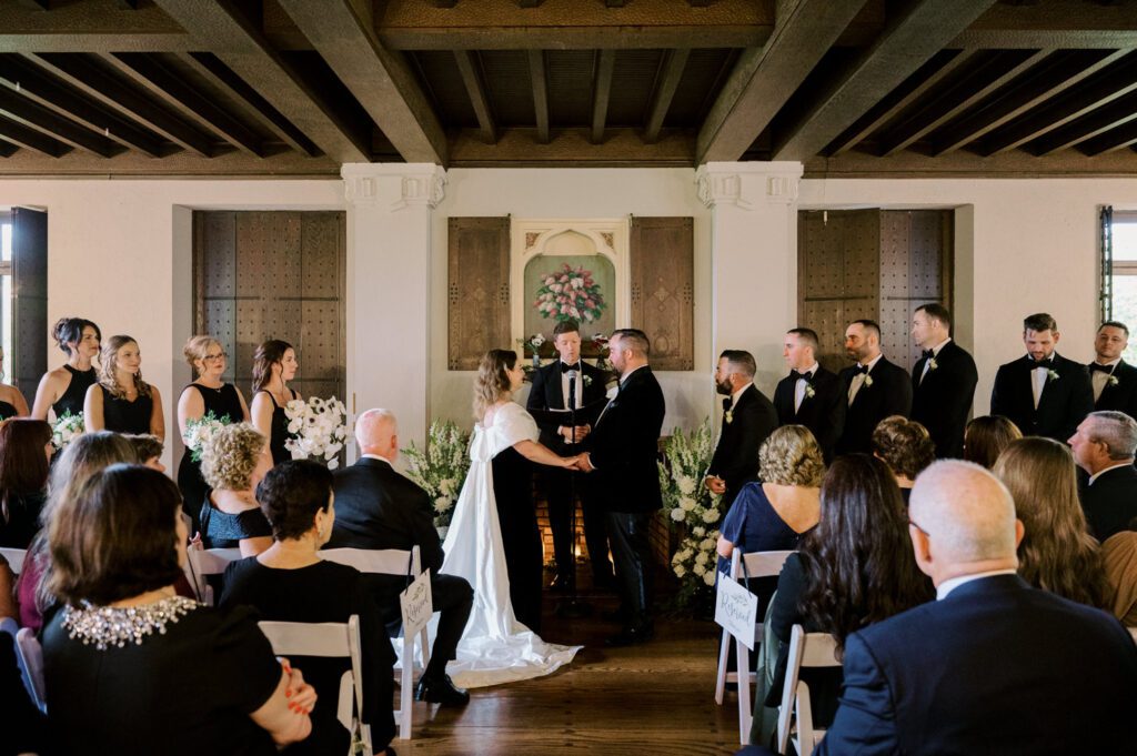 Kirsten and AJ’s September Wedding at Arrow Park, NY
Kirsten and AJ’s wedding day was a bit chilly and rainy, but their flexibility and positivity turned the day into a magical celebration. Originally planned for the garden, the ceremony was moved indoors due to the autumn rain. The staff at Arrow Park seamlessly transitioned the setup to the mansion’s main floor, creating an intimate and elegant ceremony space. The historic charm of the mansion, with its grand details and warm ambiance, added a cozy, romantic touch to their special day.
Kirsten, a talented fashion designer, surprised everyone—including her groom, AJ—by wearing a stunning black velvet strapless dress with an oversized white bow draping dramatically down the back. She designed the dress herself, and it was a show-stopper that perfectly reflected her unique style. The ceremony was heartfelt and personal, with family and friends gathering close to witness Kirsten and AJ’s vows.
After the ceremony, the main mansion was transformed to host a lively cocktail hour. Guests mingled and enjoyed delicious hors d'oeuvres while the reception space in the pavilion was being prepared. Kirsten and AJ’s attention to detail shone through in their décor choices, including the black-and-white checkered flooring that gave the pavilion a retro vibe. It was a perfect blend of modern chic and classic sophistication.
The reception began with Kirsten and AJ’s grand entrance, greeted by cheers from their guests. Their first dance was sweet and endearing, setting the tone for a night of joy and celebration. As the evening progressed, the party ramped up with enthusiastic dancing, heartfelt toasts, and even a surprise performance—a few uncles took the mic for an impromptu rap song that brought the house down.
Arrow Park provided the perfect backdrop for Kirsten and AJ’s wedding. With its blend of natural beauty and historic architecture, it’s an ideal venue for couples seeking a mix of indoor and outdoor spaces. The mansion offers a timeless elegance, while the pavilion provides a versatile setting for larger receptions.
Planning Tips for Future Couples at Arrow Park:
1. Have a Rain Plan: September weather can be unpredictable, so work with the Arrow Park staff to plan for both indoor and outdoor options. The mansion’s interiors provide a stunning alternative for ceremonies or cocktail hours.
2. Maximize the Pavilion: The pavilion’s spacious layout can accommodate various themes and setups. Consider unique flooring, lighting, or drapery to make the space your own.
3. Embrace the Venue’s Charm: Use the mansion’s historic features—like the fireplaces and vintage decor—as part of your wedding aesthetic. It’s a built-in backdrop that needs little embellishment.
4. Plan Time for Photos: Arrow Park’s grounds are breathtaking, especially in the fall. Schedule time with your photographer to capture the beauty of the lake, gardens, and mansion.
Kirsten and AJ’s wedding was a true testament to the power of creativity, adaptability, and love. Their celebration at Arrow Park was unforgettable, and I’m grateful to have been a part of their special day.
Thankful for all the wedding vendors that made this day possible:⁠
Venue: @arrowparkny
Catering: @lovenrosemary
Kirsten and AJ Arrow Park NY Wedding documented by Karis from Hey Karis New York, Brooklyn, Hudson Valley NY and Catskills NY and NJ Wedding and NYC Elopement Photographer.