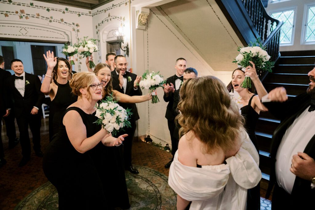 Kirsten and AJ’s September Wedding at Arrow Park, NY
Kirsten and AJ’s wedding day was a bit chilly and rainy, but their flexibility and positivity turned the day into a magical celebration. Originally planned for the garden, the ceremony was moved indoors due to the autumn rain. The staff at Arrow Park seamlessly transitioned the setup to the mansion’s main floor, creating an intimate and elegant ceremony space. The historic charm of the mansion, with its grand details and warm ambiance, added a cozy, romantic touch to their special day.
Kirsten, a talented fashion designer, surprised everyone—including her groom, AJ—by wearing a stunning black velvet strapless dress with an oversized white bow draping dramatically down the back. She designed the dress herself, and it was a show-stopper that perfectly reflected her unique style. The ceremony was heartfelt and personal, with family and friends gathering close to witness Kirsten and AJ’s vows.
After the ceremony, the main mansion was transformed to host a lively cocktail hour. Guests mingled and enjoyed delicious hors d'oeuvres while the reception space in the pavilion was being prepared. Kirsten and AJ’s attention to detail shone through in their décor choices, including the black-and-white checkered flooring that gave the pavilion a retro vibe. It was a perfect blend of modern chic and classic sophistication.
The reception began with Kirsten and AJ’s grand entrance, greeted by cheers from their guests. Their first dance was sweet and endearing, setting the tone for a night of joy and celebration. As the evening progressed, the party ramped up with enthusiastic dancing, heartfelt toasts, and even a surprise performance—a few uncles took the mic for an impromptu rap song that brought the house down.
Arrow Park provided the perfect backdrop for Kirsten and AJ’s wedding. With its blend of natural beauty and historic architecture, it’s an ideal venue for couples seeking a mix of indoor and outdoor spaces. The mansion offers a timeless elegance, while the pavilion provides a versatile setting for larger receptions.
Planning Tips for Future Couples at Arrow Park:
1. Have a Rain Plan: September weather can be unpredictable, so work with the Arrow Park staff to plan for both indoor and outdoor options. The mansion’s interiors provide a stunning alternative for ceremonies or cocktail hours.
2. Maximize the Pavilion: The pavilion’s spacious layout can accommodate various themes and setups. Consider unique flooring, lighting, or drapery to make the space your own.
3. Embrace the Venue’s Charm: Use the mansion’s historic features—like the fireplaces and vintage decor—as part of your wedding aesthetic. It’s a built-in backdrop that needs little embellishment.
4. Plan Time for Photos: Arrow Park’s grounds are breathtaking, especially in the fall. Schedule time with your photographer to capture the beauty of the lake, gardens, and mansion.
Kirsten and AJ’s wedding was a true testament to the power of creativity, adaptability, and love. Their celebration at Arrow Park was unforgettable, and I’m grateful to have been a part of their special day.
Thankful for all the wedding vendors that made this day possible:⁠
Venue: @arrowparkny
Catering: @lovenrosemary
Kirsten and AJ Arrow Park NY Wedding documented by Karis from Hey Karis New York, Brooklyn, Hudson Valley NY and Catskills NY and NJ Wedding and NYC Elopement Photographer.