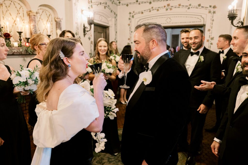 Kirsten and AJ’s September Wedding at Arrow Park, NY
Kirsten and AJ’s wedding day was a bit chilly and rainy, but their flexibility and positivity turned the day into a magical celebration. Originally planned for the garden, the ceremony was moved indoors due to the autumn rain. The staff at Arrow Park seamlessly transitioned the setup to the mansion’s main floor, creating an intimate and elegant ceremony space. The historic charm of the mansion, with its grand details and warm ambiance, added a cozy, romantic touch to their special day.
Kirsten, a talented fashion designer, surprised everyone—including her groom, AJ—by wearing a stunning black velvet strapless dress with an oversized white bow draping dramatically down the back. She designed the dress herself, and it was a show-stopper that perfectly reflected her unique style. The ceremony was heartfelt and personal, with family and friends gathering close to witness Kirsten and AJ’s vows.
After the ceremony, the main mansion was transformed to host a lively cocktail hour. Guests mingled and enjoyed delicious hors d'oeuvres while the reception space in the pavilion was being prepared. Kirsten and AJ’s attention to detail shone through in their décor choices, including the black-and-white checkered flooring that gave the pavilion a retro vibe. It was a perfect blend of modern chic and classic sophistication.
The reception began with Kirsten and AJ’s grand entrance, greeted by cheers from their guests. Their first dance was sweet and endearing, setting the tone for a night of joy and celebration. As the evening progressed, the party ramped up with enthusiastic dancing, heartfelt toasts, and even a surprise performance—a few uncles took the mic for an impromptu rap song that brought the house down.
Arrow Park provided the perfect backdrop for Kirsten and AJ’s wedding. With its blend of natural beauty and historic architecture, it’s an ideal venue for couples seeking a mix of indoor and outdoor spaces. The mansion offers a timeless elegance, while the pavilion provides a versatile setting for larger receptions.
Planning Tips for Future Couples at Arrow Park:
1. Have a Rain Plan: September weather can be unpredictable, so work with the Arrow Park staff to plan for both indoor and outdoor options. The mansion’s interiors provide a stunning alternative for ceremonies or cocktail hours.
2. Maximize the Pavilion: The pavilion’s spacious layout can accommodate various themes and setups. Consider unique flooring, lighting, or drapery to make the space your own.
3. Embrace the Venue’s Charm: Use the mansion’s historic features—like the fireplaces and vintage decor—as part of your wedding aesthetic. It’s a built-in backdrop that needs little embellishment.
4. Plan Time for Photos: Arrow Park’s grounds are breathtaking, especially in the fall. Schedule time with your photographer to capture the beauty of the lake, gardens, and mansion.
Kirsten and AJ’s wedding was a true testament to the power of creativity, adaptability, and love. Their celebration at Arrow Park was unforgettable, and I’m grateful to have been a part of their special day.
Thankful for all the wedding vendors that made this day possible:⁠
Venue: @arrowparkny
Catering: @lovenrosemary
Kirsten and AJ Arrow Park NY Wedding documented by Karis from Hey Karis New York, Brooklyn, Hudson Valley NY and Catskills NY and NJ Wedding and NYC Elopement Photographer.